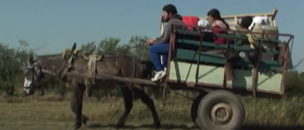 Una familia migrando con un carro tirado por un caballo.