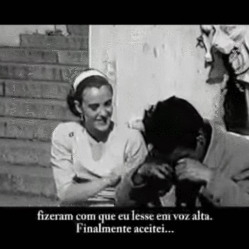 Hombre y mujer sentados en una escalera conversando en una imagen en blanco y negro con subtítulos en portugués.