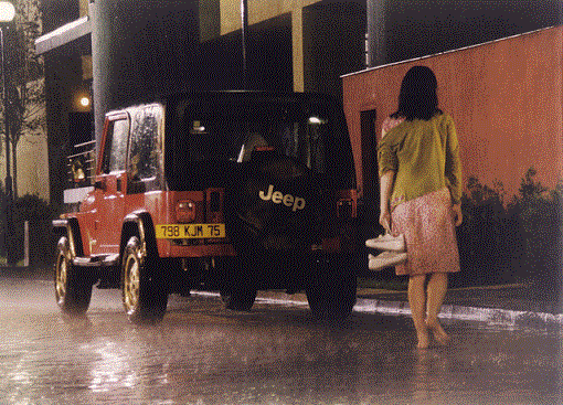 Una mujer caminando bajo la lluvia y sin zapatos