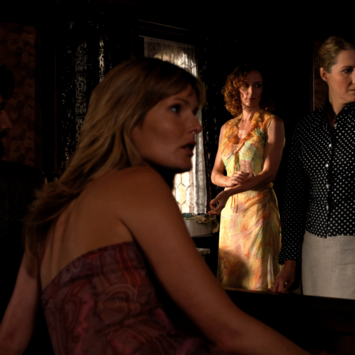 Escena interior de la película Belhorizon con tres mujeres y un hombre en una habitación iluminada tenuemente.