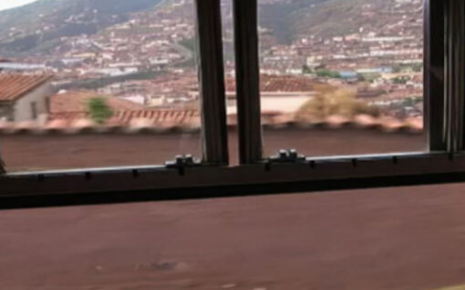 Fotograma de la película Americano, se puede ver un pueblecito desde la ventana de un autobús.