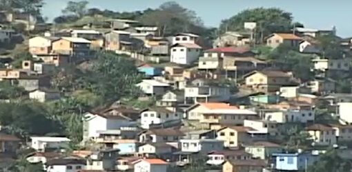 Una ladera densamente poblada muestra numerosas casas de distintos colores y tamaños, rodeadas de vegetación y caminos angostos.