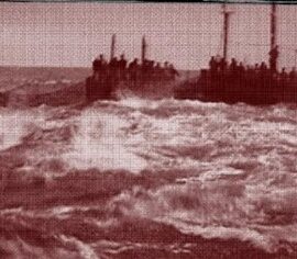 Varios barcos dispuestos, llenos de personas, uno tras otros formando el cerco donde los atunes están acorralados agitando el mar.