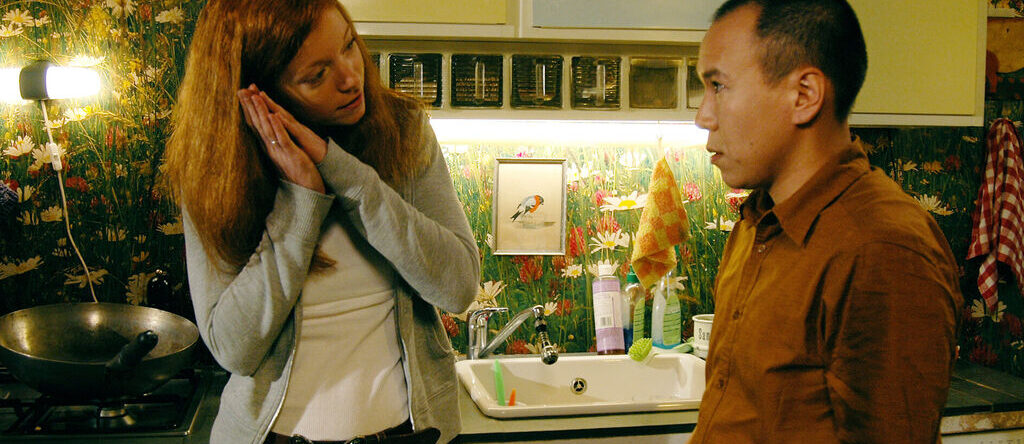 Fotograma de "Chinese take away". Dos personas comunicándose en una cocina.