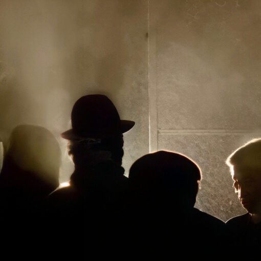 Fotograma de la ciudad Dóctica, un ambiente oscuro donde se aprecia las sombras de varias personas.