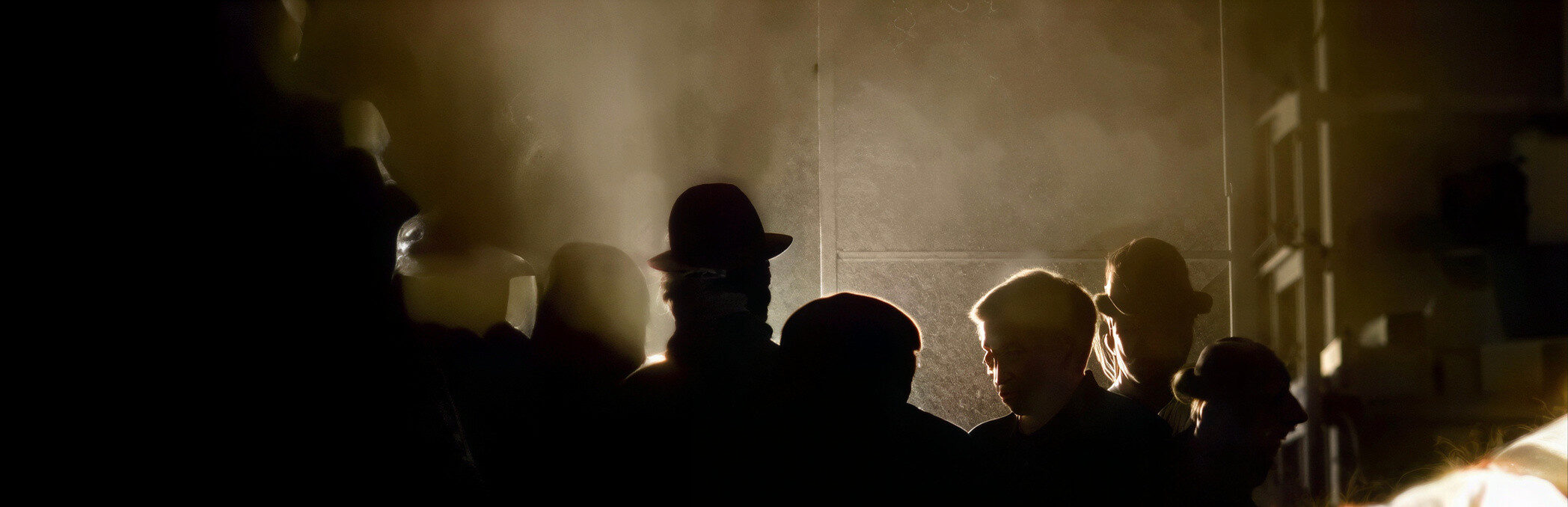 Fotograma de la ciudad Dóctica, un ambiente oscuro donde se aprecia las sombras de varias personas.
