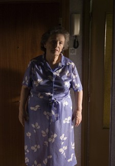 Protagonista del cortometraje, vistiendo un vestido lila con estampado de flores blancas.