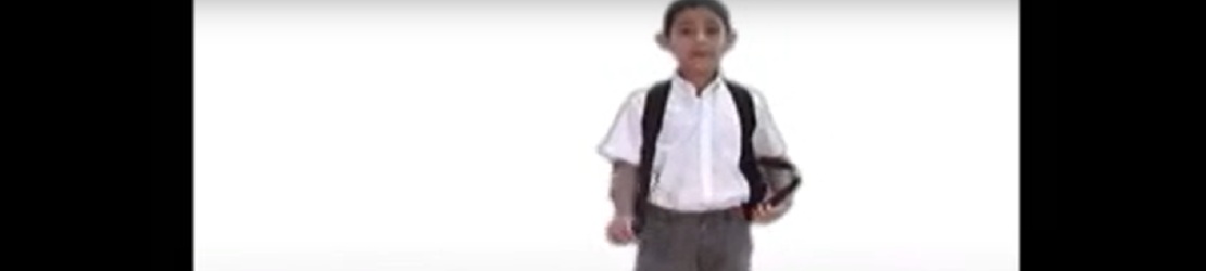 Un niño con uniforme escolar y mochila está de pie sobre un fondo blanco. Sostiene un cuaderno en una mano y mira al frente.