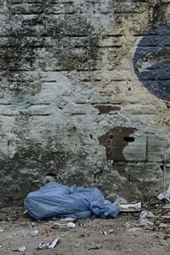 Póster de "La bolsa azul", en el que aparece una esquina de la calle sucia con una bolsa de basura azul tirada.