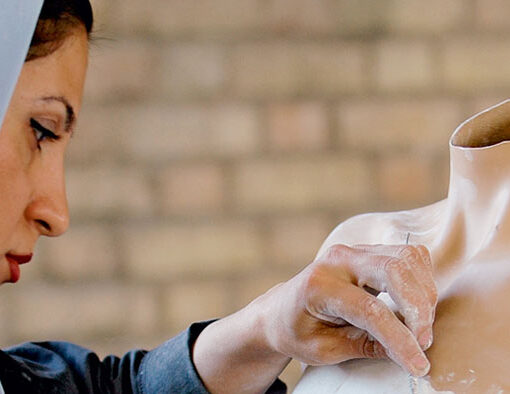 Primer Corte. Fotograma. Se ve a una mujer manipulando y limpiando un maniquí femenino mutilado.