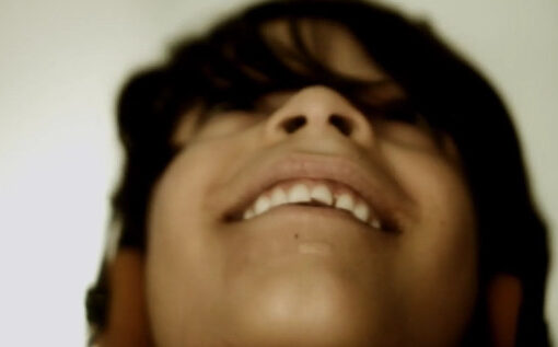 Un chico con audifonos mira hacia arriba.