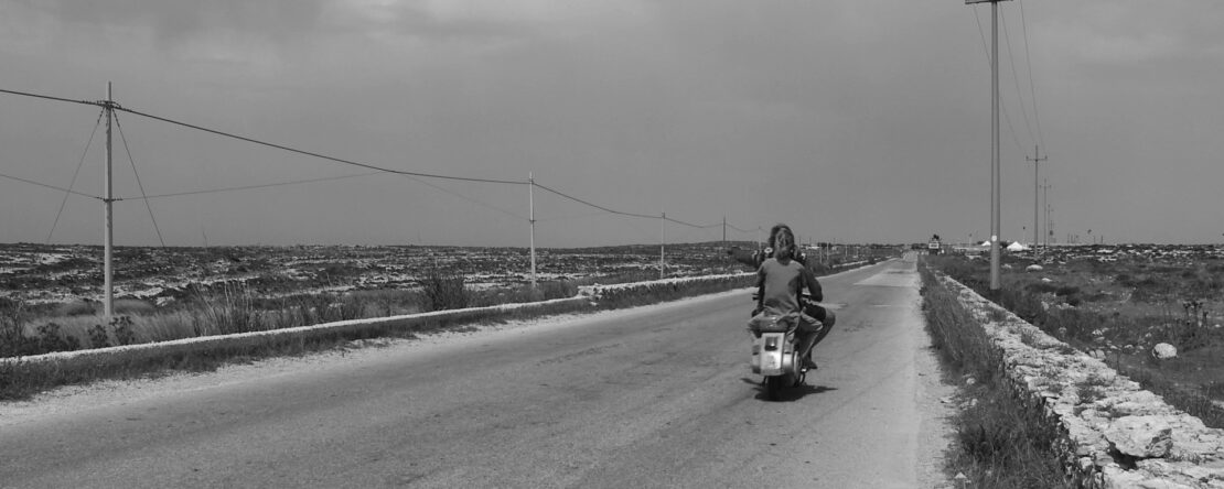 Fotograma de una carretera de Lampedusa con la protagonista viajando en una motocicleta