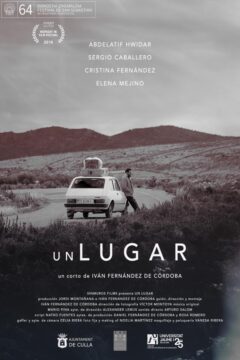 Cartel del cortometraje Un lugar, donde se ve a un hombre apoyado en un coche detenido en una carretera rural, con equipaje en el techo, rodeado de un paisaje amplio y montañoso que transmite aislamiento, espera y tránsito.