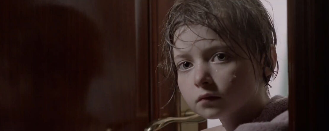 Ainhoa. Fotograma del cortometraje. Se ve a una niña pequeña con el pelo lavado en una habitación.