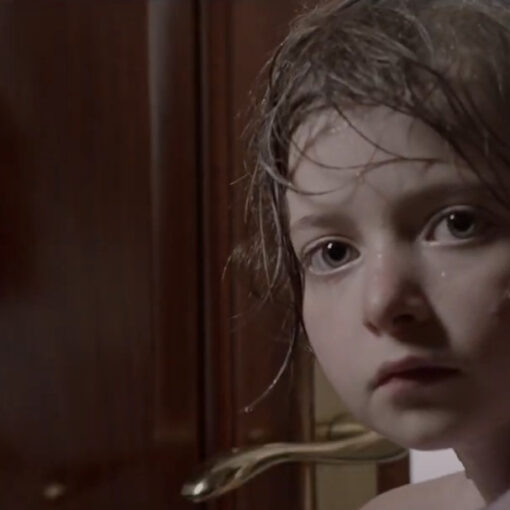 Ainhoa. Fotograma del cortometraje. Se ve a una niña pequeña con el pelo lavado en una habitación.