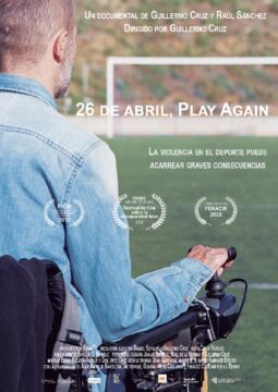 Cartel de la película "26 de Abril, juega otra vez". Un hombre en silla de ruedas observa un campo de fútbol vacío.