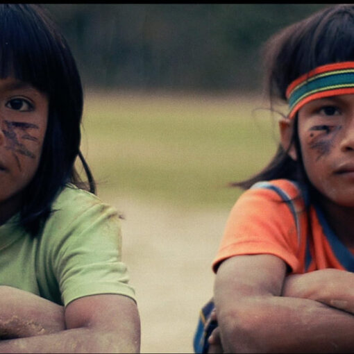 Dos niños nativos americanos nos miran fijamente, con una expresión serena y profunda que transmite calma y dignidad. Sus rostros, enmarcados por la luz natural.