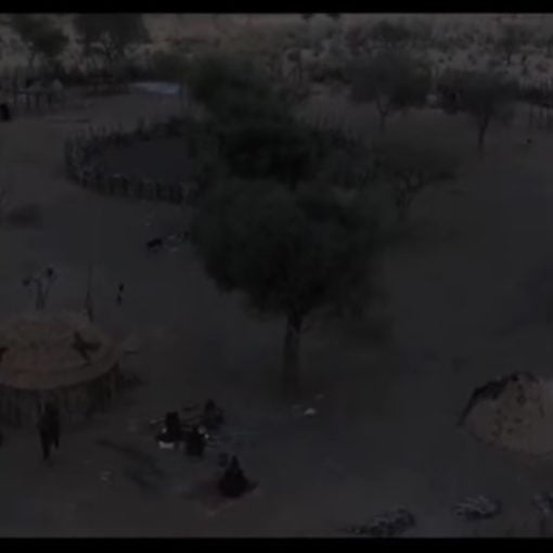 El futuro detrás de ti. Fotograma del documental. Se ve un pueblo de chozas en el atardecer.