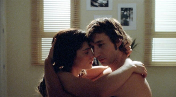 Chupertópico. Fotograma de la película. Se muestra a lo que parece una pareja de mujer y hombre en una posición de abrazo.