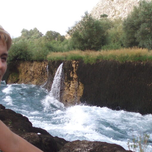 Fotograma de "No olvidar, voces más allá del olvido". Una mujer sonríe delante de una cascada.