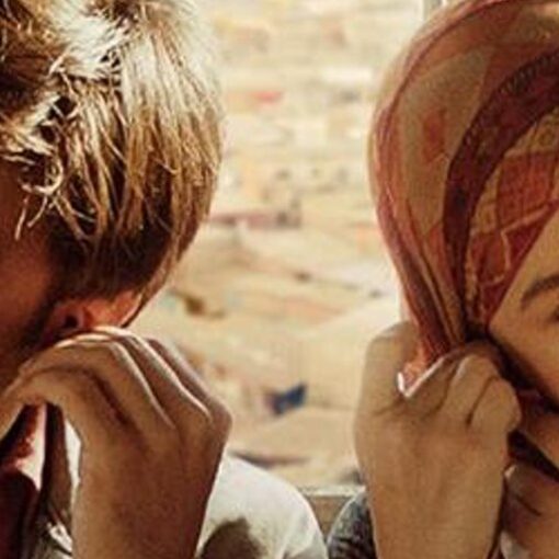 Fotograma de Un chico de barrio en el que aparecen un hombre y una mujer que comparten auriculares, uno cada uno.