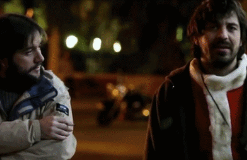 Fotograma de En mal estado en el que aparecen dos hombres caminando por la calle de noche y hablando entre ellos.