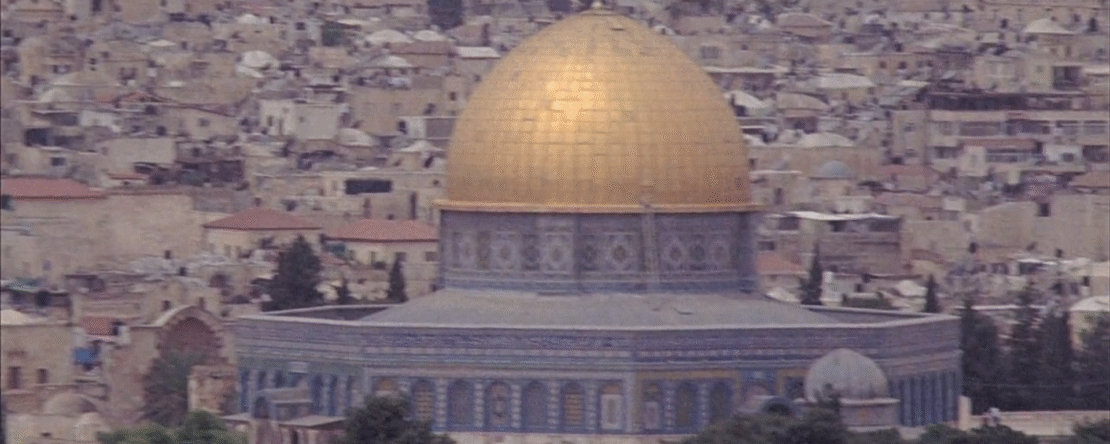 Vista panorámica de la Cúpula de la Roca en Jerusalén con su cúpula dorada, rodeada por edificaciones históricas de la ciudad.