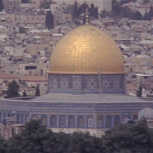 Vista panorámica de la Cúpula de la Roca en Jerusalén con su cúpula dorada, rodeada por edificaciones históricas de la ciudad.