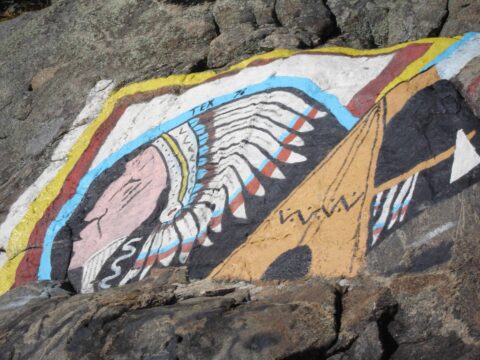Fotograma del documental ¿En qué son buenos los indios?. Imagen de una bandera india encima de unas rocas.