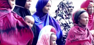 Fotograma del documental Lamento de los refugiados, varias mujeres y niñas, todas mirando para el mismo lado.