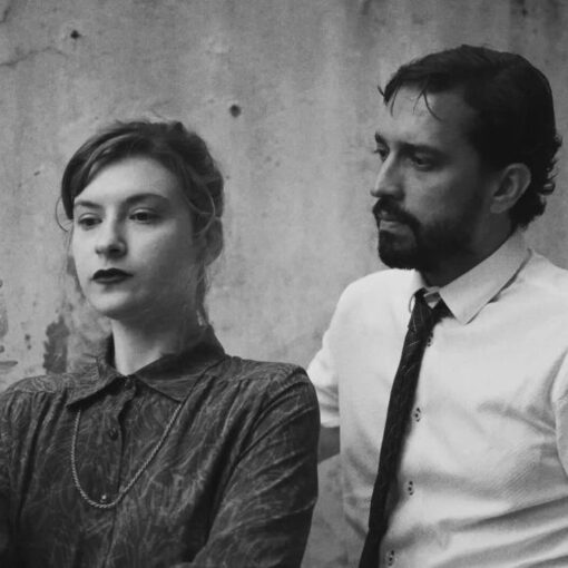 Un hombre y una mujer en blanco y negro, con la mujer sosteniendo un objeto translúcido.