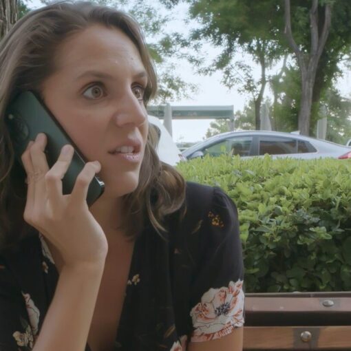 Mujer hablando por teléfono al aire libre con expresión de sorpresa.