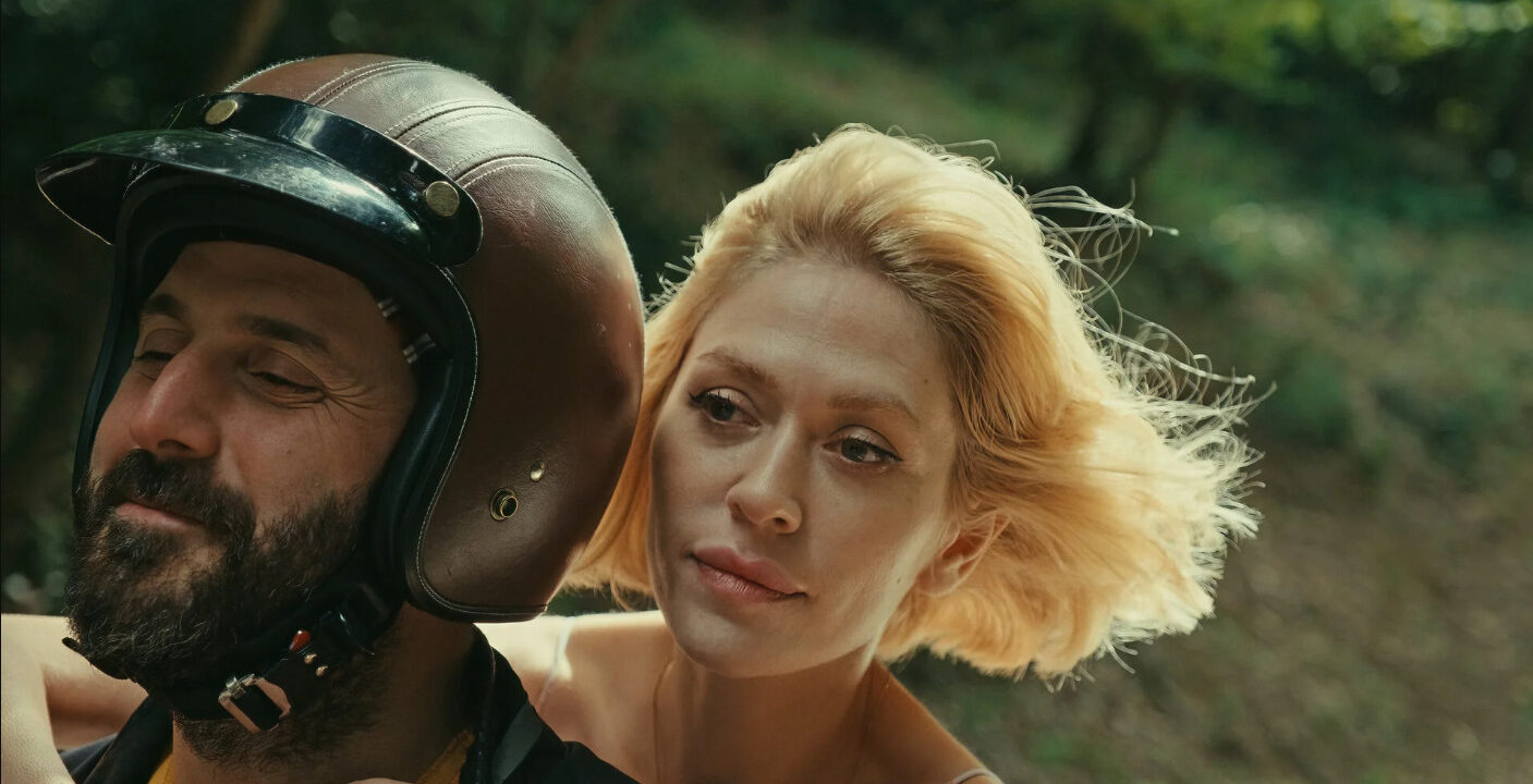 Fotograma del largometraje Rosinante donde un hombre y una mujer viajan en moto.