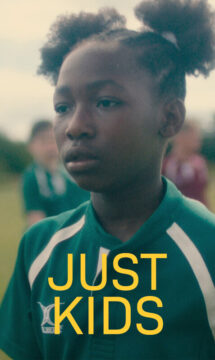 Cartel del corto Solo niños. Es un fotograma en el que aparece la Alisha, una niña negra con ropa deportiva verde y sobre esta el titulo del corto en color amarillo.