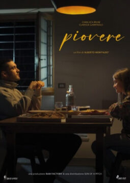 En el cartel del cortometraje Llover, un joven y una niña cenan juntos bajo una luz cálida. Sentados frente a frente, comparten un momento silencioso que refleja el vínculo familiar en construcción. Sobre la mesa hay platos y una botella de agua, en un entorno sencillo e íntimo que transmite ternura y contención emocional.
