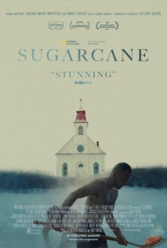 Cartel del documental Sugarcane. En primer plano, un hombre indígena sin camiseta se encuentra agachado dentro de un lago o río, rodeado de niebla azulada. Al fondo, destaca una iglesia blanca con techo rojo. La imagen transmite una atmósfera solemne y silenciosa.