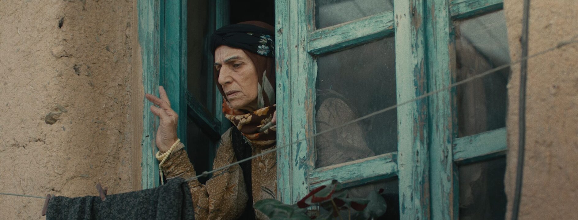 Fotograma del cortometraje Hijo que muestra una mujer de avanzada edad asomada a una ventana.