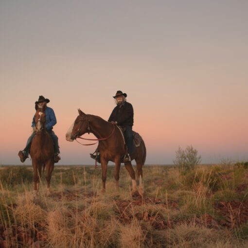 Fotograma de Yurlu | País dos hombres vestidos de vaqueros sobre caballos en un paisaje desértico. En el cielo, está la luna.